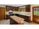 Traditional kitchen featuring dark wood cabinets, a central island, and modern appliances at 11824 E Basswood Ln, Franktown, CO 80116