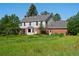 Spacious two-story home with brick accents surrounded by a lush green yard and mature trees at 11824 E Basswood Ln, Franktown, CO 80116