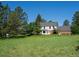 Charming home with a large yard featuring mature trees and a well-maintained lawn at 11824 E Basswood Ln, Franktown, CO 80116