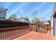 Backyard view featuring a deck, wood fence, mulch ground covering, and mature trees under a clear blue sky at 19828 E Brown Pl, Aurora, CO 80013