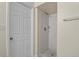 Bathroom shower with white tile, glass door, and tiled floor, next to the bathroom door at 19828 E Brown Pl, Aurora, CO 80013