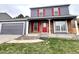 Charming two-story home featuring a brick facade, red door and shutters, and an attached garage at 19828 E Brown Pl, Aurora, CO 80013