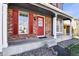 Inviting front porch showcasing brickwork, white columns, and a vibrant red front door at 19828 E Brown Pl, Aurora, CO 80013