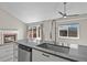 Modern kitchen with island sink, stainless steel appliances, fireplace, and sliding door to deck at 19828 E Brown Pl, Aurora, CO 80013