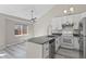Bright open floorplan kitchen with island sink, white cabinets, and stainless steel appliances at 19828 E Brown Pl, Aurora, CO 80013
