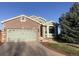 Charming brick home featuring an attached two-car garage, well-kept lawn, and shade tree at 1998 E 100Th Pl, Thornton, CO 80229
