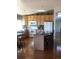 Efficient kitchen features warm wood cabinets, white appliances, and a center island with seating at 1998 E 100Th Pl, Thornton, CO 80229