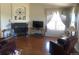 Living room area featuring hardwood flooring, a fireplace, comfortable recliners, and large windows at 1998 E 100Th Pl, Thornton, CO 80229