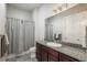 Well-lit bathroom features granite counters, modern fixtures, and a shower with grey tile accents at 23130 E Del Norte Cir, Aurora, CO 80016