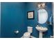 Powder room with blue walls, round mirror, pedestal sink, and modern lighting at 23130 E Del Norte Cir, Aurora, CO 80016