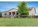 Exterior of house with covered porch and stone pillars and black fence in front at 23130 E Del Norte Cir, Aurora, CO 80016
