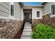 Inviting front entrance with stone accents, a covered porch, and a well-maintained landscape at 23130 E Del Norte Cir, Aurora, CO 80016