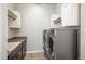 Clean laundry room with white cabinets, countertop, modern washer and dryer at 23130 E Del Norte Cir, Aurora, CO 80016
