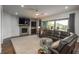 Spacious living room with a fireplace, ceiling fan, and access to the outdoor patio through sliding glass doors at 23130 E Del Norte Cir, Aurora, CO 80016
