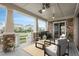 Covered porch with outdoor seating, ceiling fans, stone pillars and houses in background at 23130 E Del Norte Cir, Aurora, CO 80016