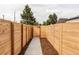 Newly installed horizontal wooden fence and concrete walkway, with mulch landscaping, around property at 4025 E Martin Luther King Jr, Denver, CO 80207