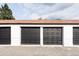Three-car garage with black doors and white painted brick exterior under blue sky at 4025 E Martin Luther King Jr, Denver, CO 80207