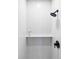 Modern bathroom shower featuring white subway tile, sleek black fixtures, and a built-in shelf at 4025 E Martin Luther King Jr, Denver, CO 80207