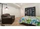Bedroom features a comfortable leather armchair, a modern bookshelf, and ample natural light at 1551 S Grant St, Denver, CO 80210