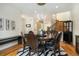 Elegant dining room features hardwood floors, stylish lighting, backyard view, and staircase access to the second floor at 1551 S Grant St, Denver, CO 80210