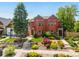 Beautiful red brick home with well-maintained front yard landscaping, trees, and walkway at 1551 S Grant St, Denver, CO 80210