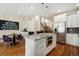 Open kitchen features a large island with stainless steel microwave, white cabinets, granite countertops, and hardwood floors at 1551 S Grant St, Denver, CO 80210