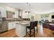Open concept kitchen with white cabinets, granite countertops, stainless steel appliances, hardwood floors, and island seating at 1551 S Grant St, Denver, CO 80210