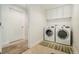 A laundry room features modern machines, sleek white cabinets, and neutral walls at 1551 S Grant St, Denver, CO 80210