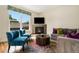 Cozy living room showcasing a fireplace, large window, stylish seating, and hardwood floors at 1551 S Grant St, Denver, CO 80210