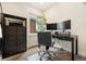 Bright office space featuring a dark desk, two monitors, a contemporary black bookshelf, and neutral walls at 1551 S Grant St, Denver, CO 80210