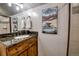 Bathroom vanity with granite countertop, wood cabinets, decorative mirror, and nice light fixtures at 107 Ski Watch Rd # 32, Breckenridge, CO 80424
