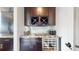 Stylish bar area with a wine refrigerator, granite countertops, and glass storage for a modern touch at 16491 Fairway Dr, Commerce City, CO 80022