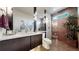 Modern bathroom featuring sleek vanity, updated lighting, and tiled shower with glass door at 16491 Fairway Dr, Commerce City, CO 80022