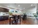 Inviting dining area with bar, multiple dining tables, and wood floors at 16491 Fairway Dr, Commerce City, CO 80022