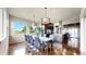 Bright dining area with a modern glass table, designer lighting, and a seamless flow to the kitchen at 16491 Fairway Dr, Commerce City, CO 80022