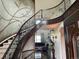 Elegant foyer with curved staircase, decorative iron railings, wood floors, and views of the living room at 16491 Fairway Dr, Commerce City, CO 80022