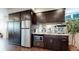 Wet bar area includes stainless steel fridge, sink, microwave, and dark wood cabinets at 16491 Fairway Dr, Commerce City, CO 80022