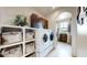 Convenient laundry area with modern appliances, built-in cabinets, and shelving for storage at 16491 Fairway Dr, Commerce City, CO 80022