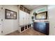 Functional mudroom with ample storage, including built-in cabinets, open shelving, and a convenient bench at 16491 Fairway Dr, Commerce City, CO 80022