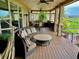 Relax on this covered patio with plush seating, a fire pit, ceiling fans, and an outdoor bar overlooking a golf course at 16491 Fairway Dr, Commerce City, CO 80022