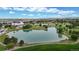 Aerial view of a community pond with walking paths, picnic areas, and beautiful surrounding landscaping at 16491 Fairway Dr, Commerce City, CO 80022