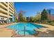 Relaxing community pool and spa surrounded by lounge chairs, landscaping, and building views on a clear sunny day at 1301 Speer Blvd # 702, Denver, CO 80204