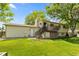 Exterior shot of the back of the house featuring a deck, stairs, and a spacious grassy yard at 11199 Dahlia Pl, Thornton, CO 80233