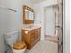Bathroom featuring a classic wood vanity, a toilet, and an open doorway to a hallway at 11199 Dahlia Pl, Thornton, CO 80233