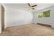 A bright, spacious bedroom with neutral carpet, white walls, and a ceiling fan at 11199 Dahlia Pl, Thornton, CO 80233
