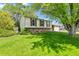 Traditional two-story home with brown shutters, a well-manicured lawn and mature trees at 11199 Dahlia Pl, Thornton, CO 80233