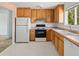 Efficient kitchen features oak cabinets, updated appliances, and linoleum floors at 11199 Dahlia Pl, Thornton, CO 80233