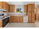 Efficient kitchen features classic oak cabinets, a window over the sink and an included white dishwasher at 11199 Dahlia Pl, Thornton, CO 80233