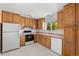 This kitchen offers oak cabinets, updated appliances, and natural light from the window over the double sink at 11199 Dahlia Pl, Thornton, CO 80233