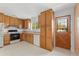 Full kitchen with oak cabinets, appliances, and exterior door at 11199 Dahlia Pl, Thornton, CO 80233